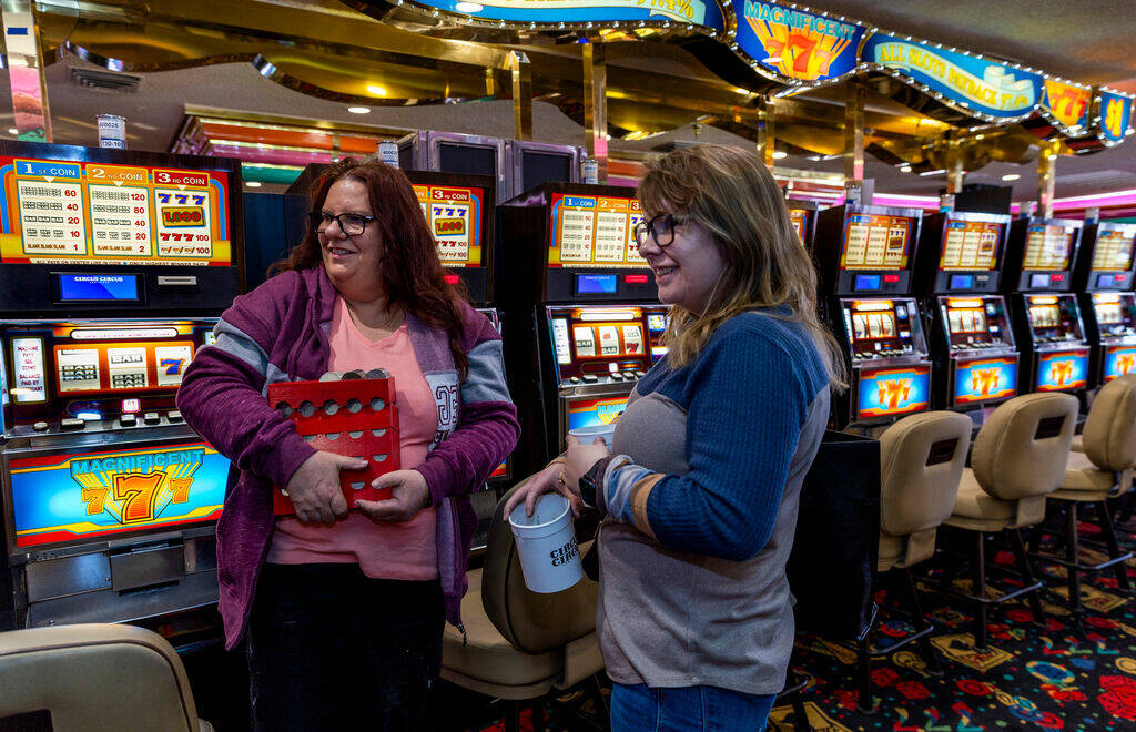 Wendy Womack of Texas, left, holds racks of coins she won beside her daughter Jacy Pickens from ...