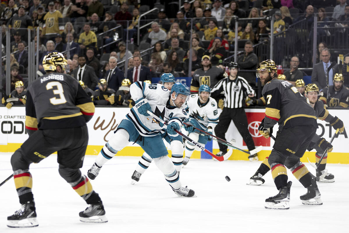 San Jose Sharks center Tomas Hertl (48) sends the puck up the ice while Vegas Golden Knights de ...