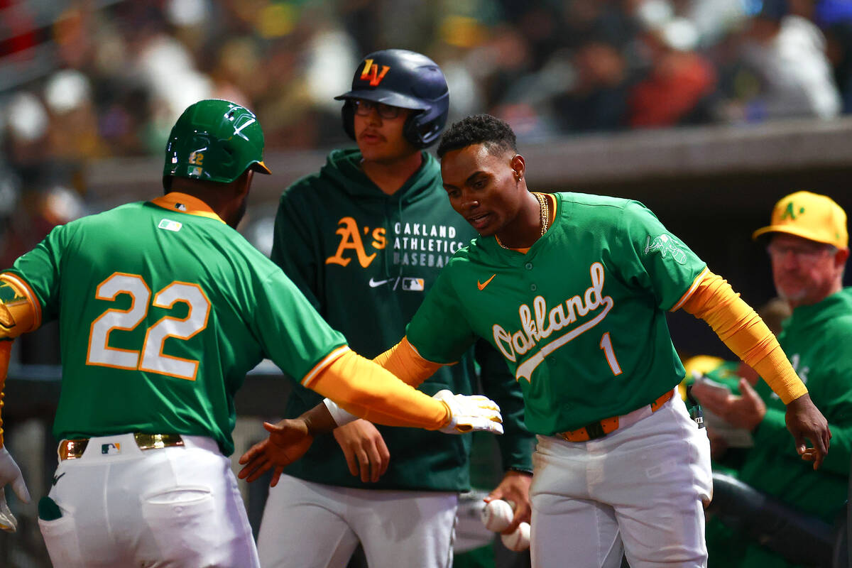 Oakland Athletics outfielder Miguel Andujar (22) slaps hands with center fielder Esteury Ruiz ( ...
