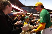 Oakland Athletics second baseman Zack Gelof (20) signs autographs for fans before a Major Leagu ...