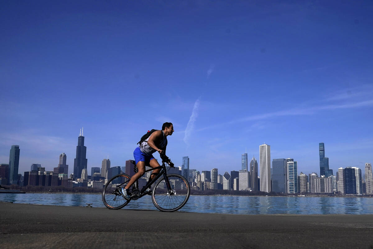 FILE - A cyclist travels around Lake Michigan near the Adler Planetarium Monday, Feb. 26, 2024, ...