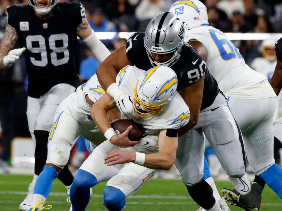 Raiders defensive tackle Jerry Tillery (90) takes down Los Angeles Chargers quarterback Easton ...