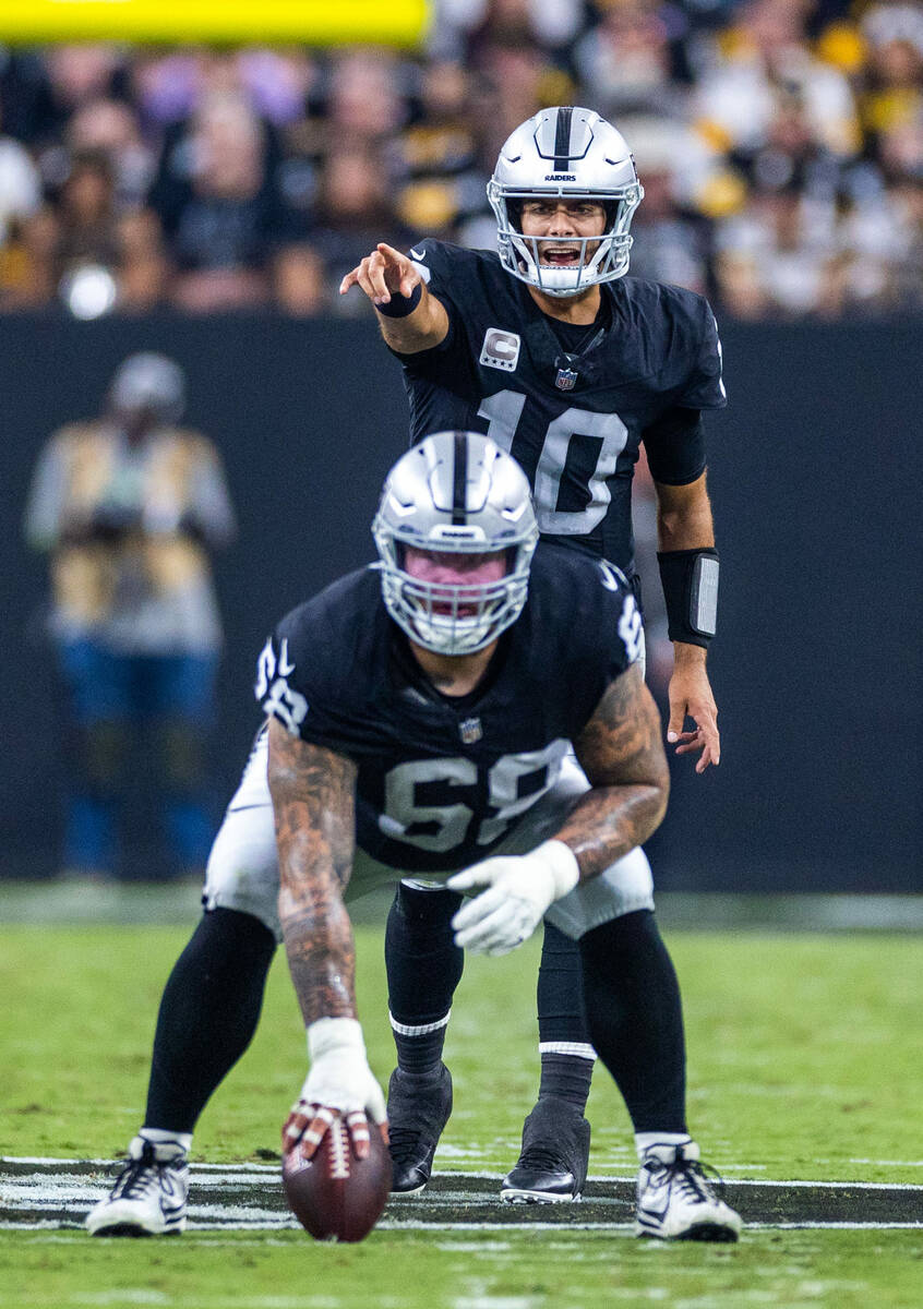 Raiders quarterback Jimmy Garoppolo (10) calls an adjustment awaiting the snap from center Andr ...