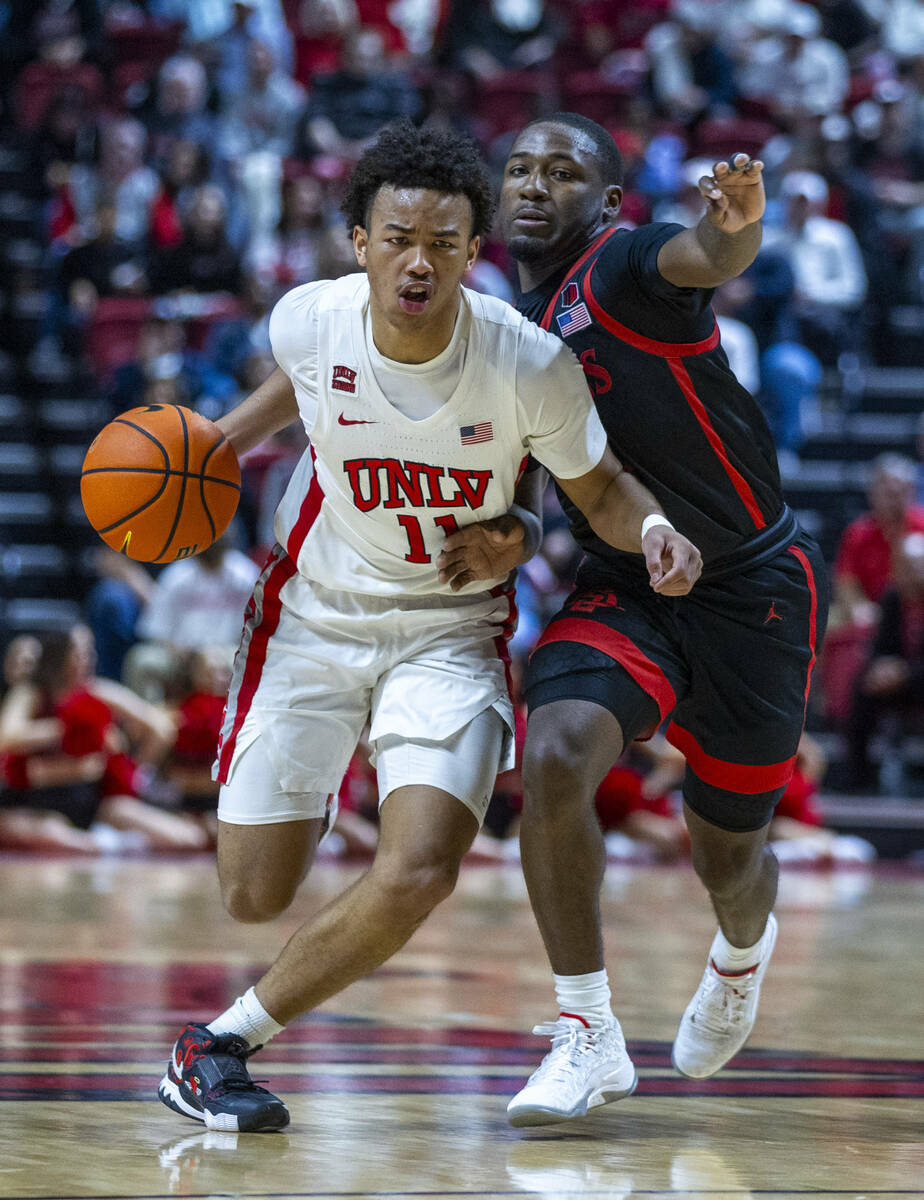 UNLV guard Dedan Thomas Jr. (11) bodies up for a drive against San Diego State Aztecs guard Dar ...
