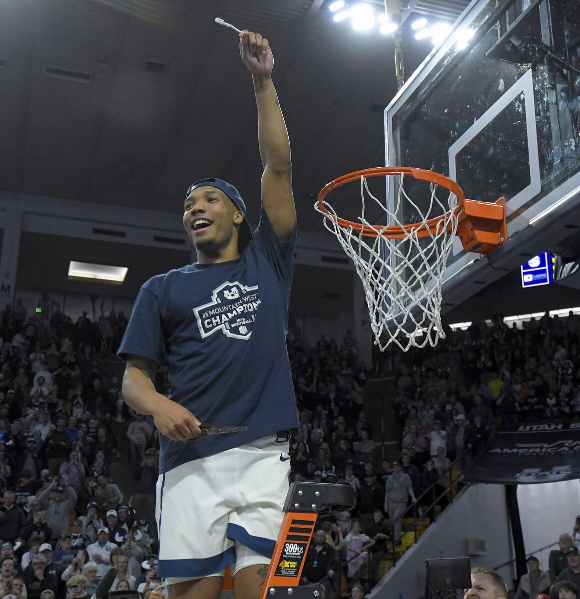 Utah State guard Darius Brown II holds up a piece of the net after the team's win over New Mexi ...
