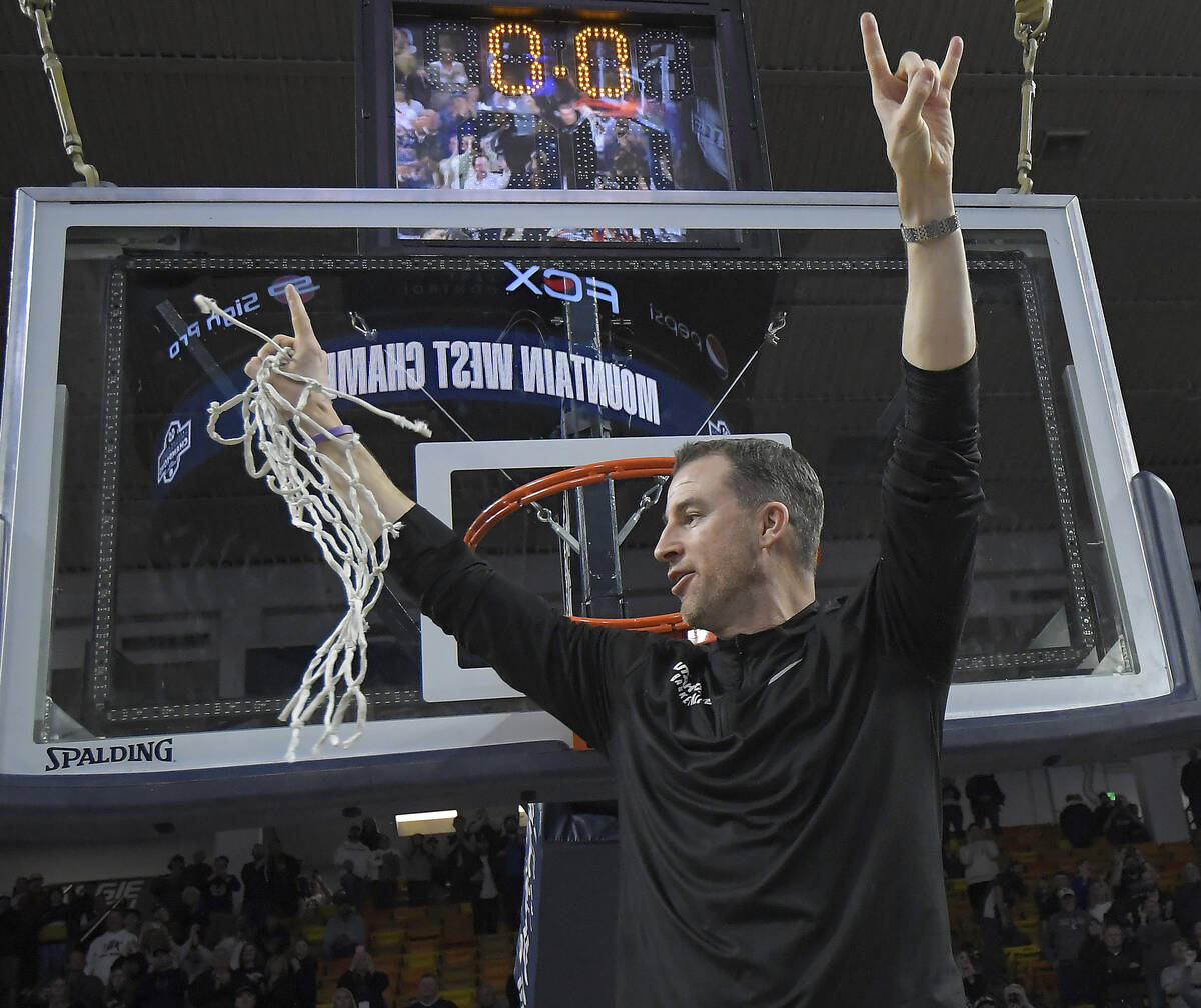Utah State coach Danny Sprinkle celebrates after cutting down the net following the team's win ...