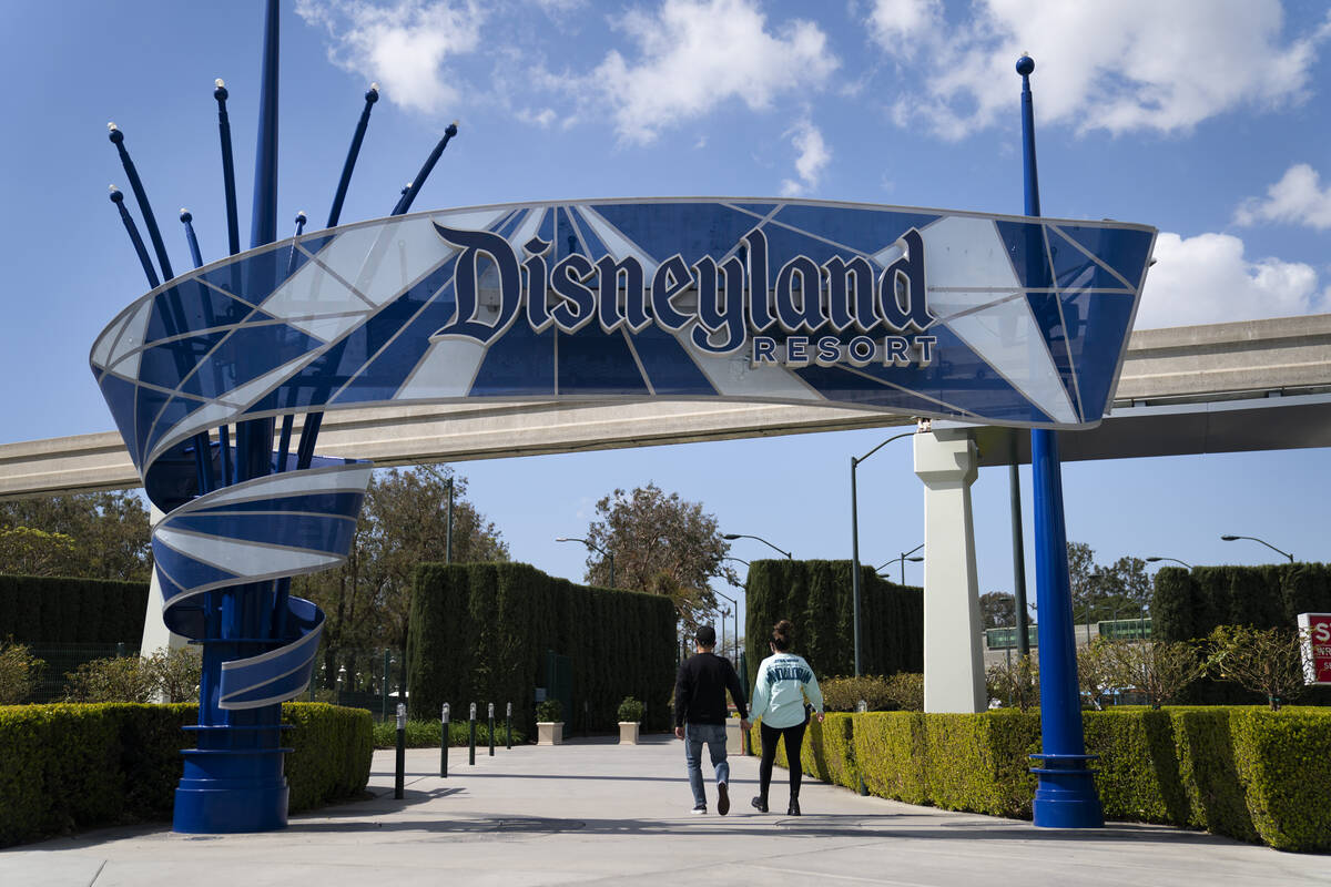 Two visitors enter Disneyland Resort in Anaheim, Calif., March 9, 2021. Disney is seeking appro ...