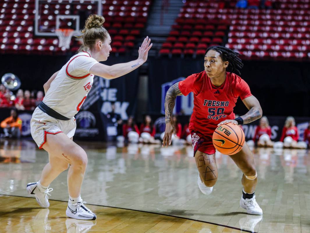 Fresno State’s guard Deajanae Harvey (50) dribbles past UNLV’s guard Ashley Scogg ...