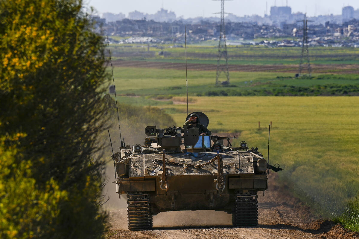 Israeli soldiers drive an APC near the border with Gaza Strip, in southern Israel, Sunday, Marc ...