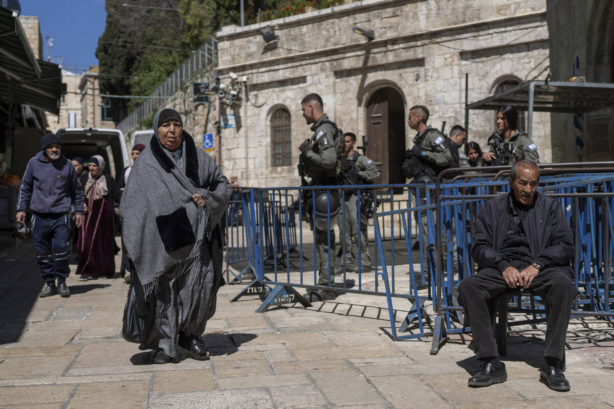 Israeli border police officers stand guard as Palestinians walk by in Jerusalem's Old City on t ...
