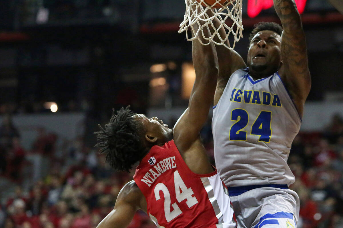 UNR Wolf Pack forward Jordan Caroline (24) takes a shot while under pressure from UNLV Rebels f ...