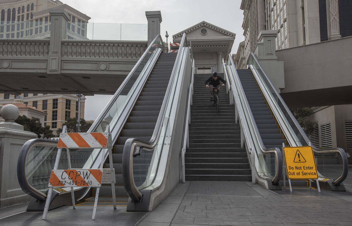 Las Vegan Matt Cremeans bikes down stairs of a pedestrian bridge on the Strip on Wednesday, Mar ...