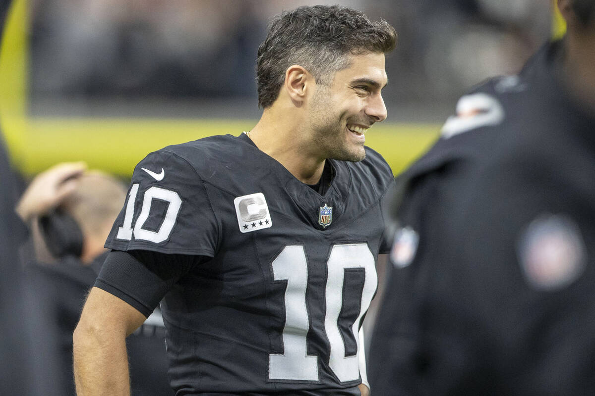 Raiders quarterback Jimmy Garoppolo (10) smiles as he watches the team play from the sideline d ...