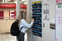 A ninth grader places her cellphone in to a phone holder as she enters class at Delta High Scho ...