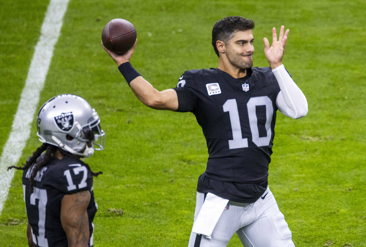 Raiders quarterback Jimmy Garoppolo (10) warms up beside wide receiver Davante Adams (17) as th ...