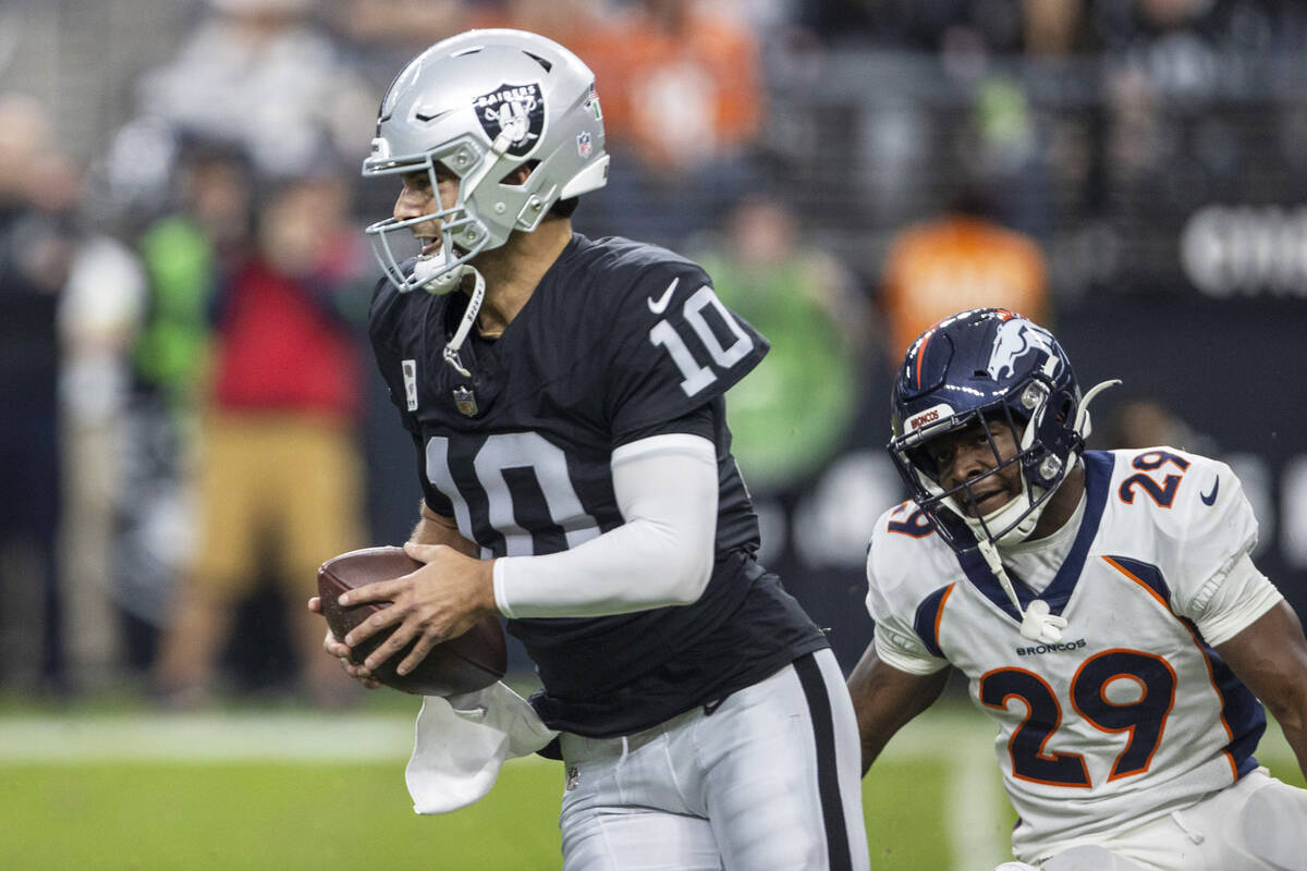 Raiders quarterback Jimmy Garoppolo (10) scrambles as he’s pursued by Denver Broncos cor ...