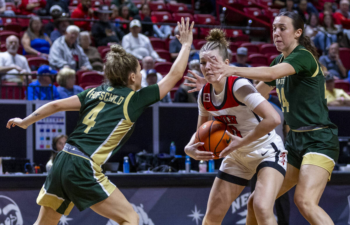 UNLV Lady Rebels guard Ashley Scoggin (0) looks for an outlet pass between Colorado State Rams ...