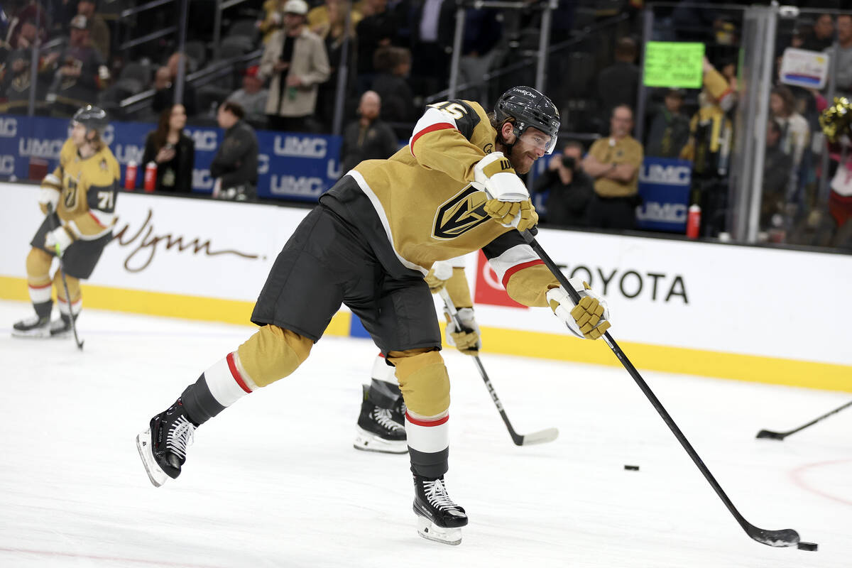 Golden Knights defenseman Noah Hanifin (15) shoots during warmups before an NHL hockey game at ...