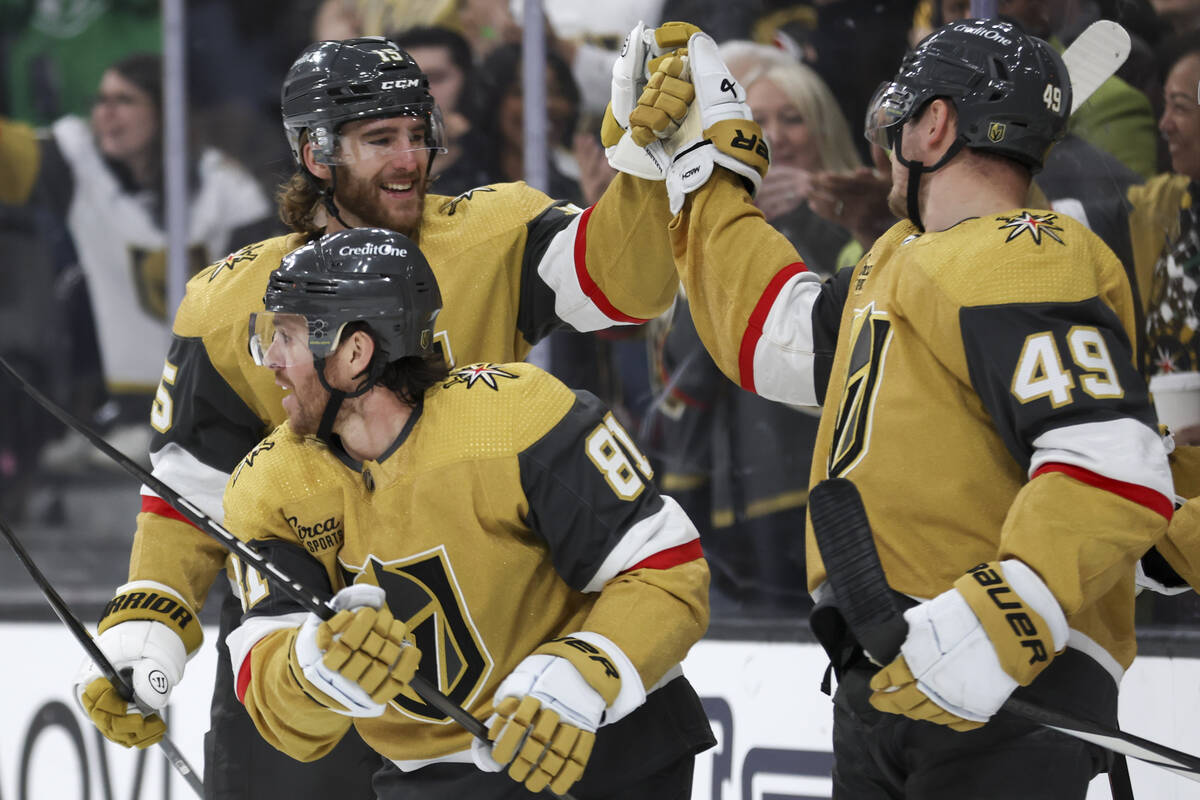 Golden Knights defenseman Noah Hanifin (15) and center Ivan Barbashev (49) bump fists over righ ...