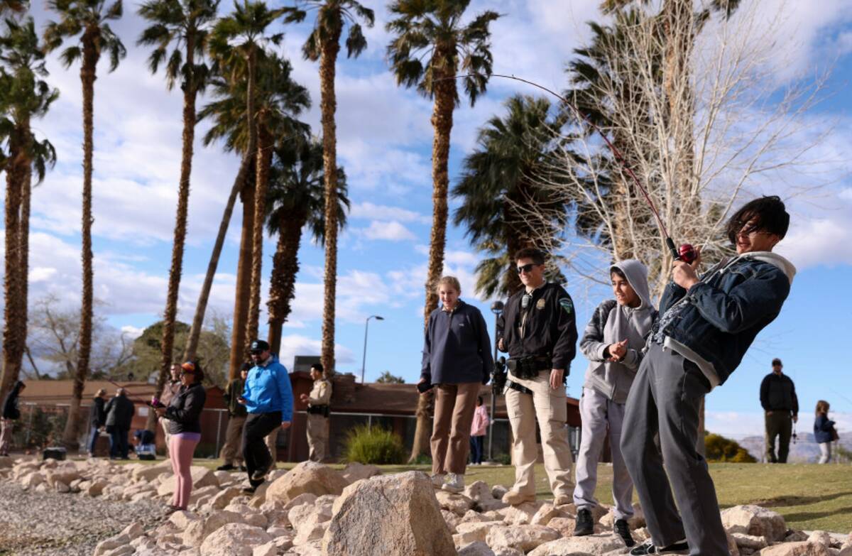 Zion Garcia, 15, right, reels in a fish next to his brother, Angelo Garcia, 11, during a Latino ...