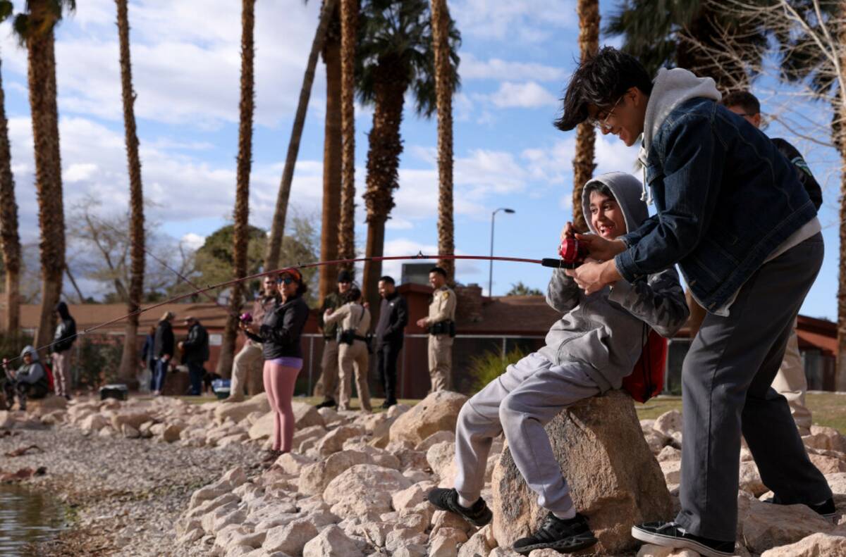 Angelo Garcia, 11, and his brother Zion Garcia, 15, reel in a fish during a Latino Outdoors eve ...