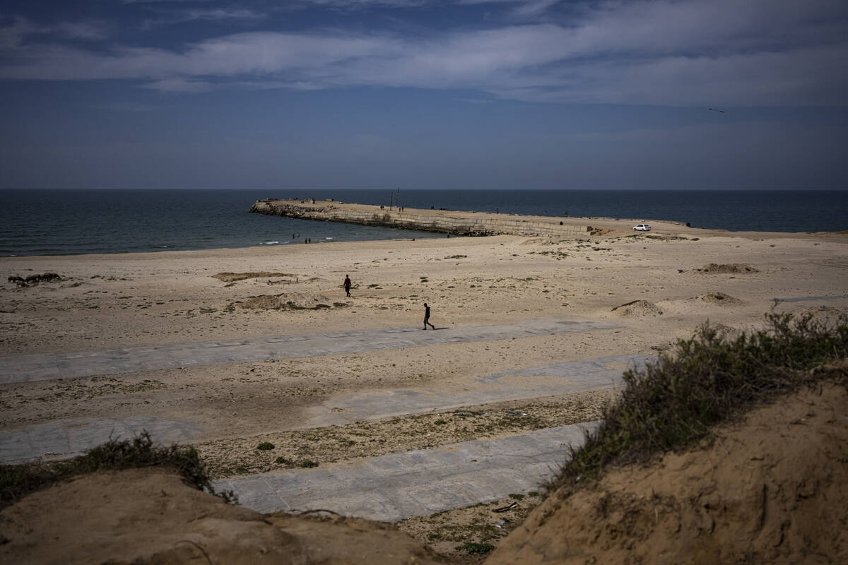 Palestinians walk by a pier that could be used to bring humanitarian aid to the Gaza Strip in K ...