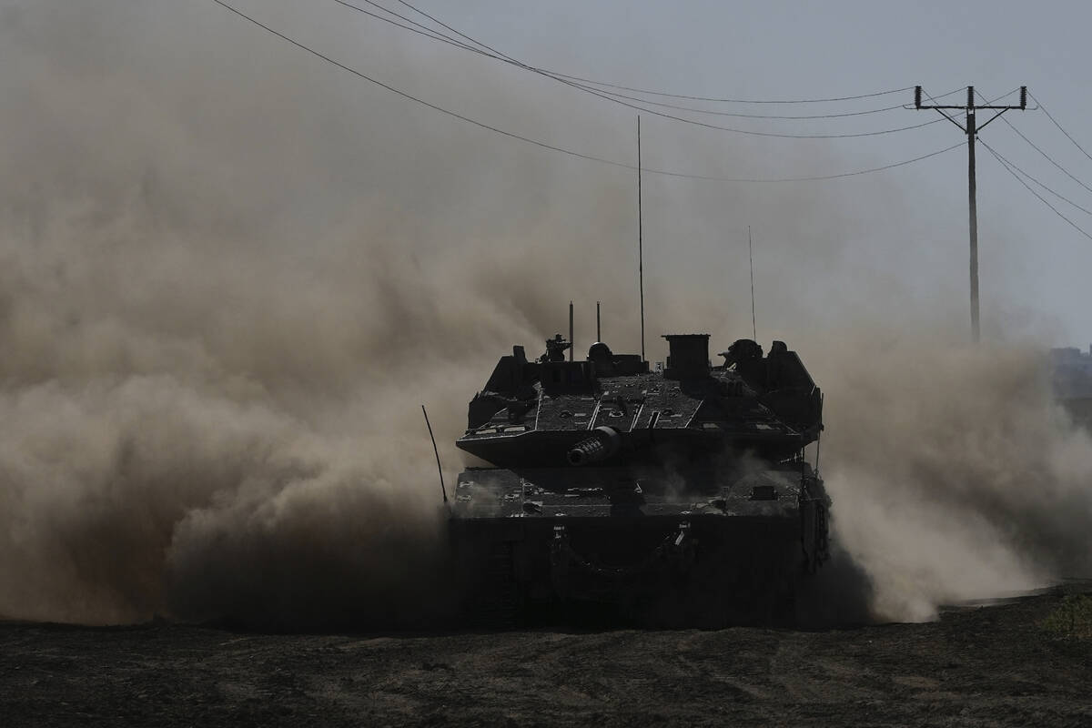An Israeli tank moves near the Gaza Strip border in southern Israel, Wednesday, March 13, 2024. ...