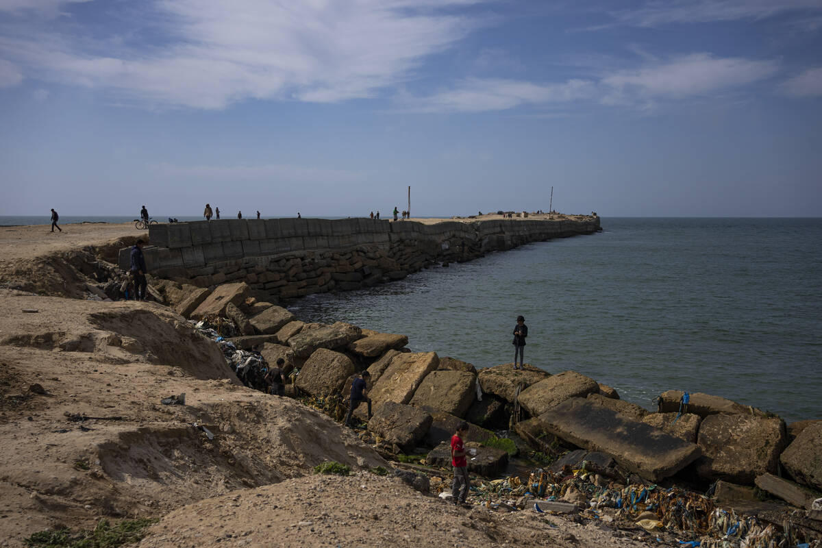 Palestinians walk by a pier that could be used to bring humanitarian aid to the Gaza Strip in K ...