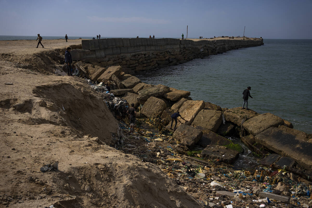 Palestinians walk by a pier that could be used to bring humanitarian aid to the Gaza Strip in K ...