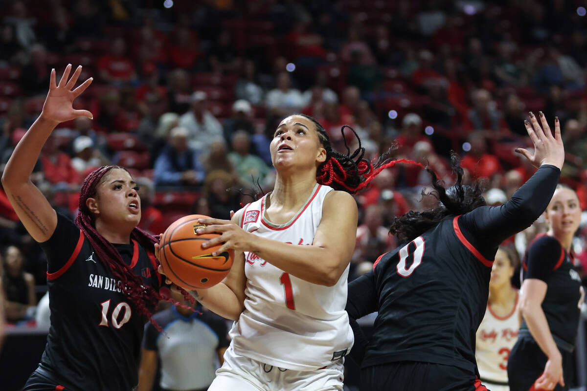 UNLV Lady Rebels forward Nneka Obiazor (1) drives between San Diego State Aztecs guards Mia Dav ...