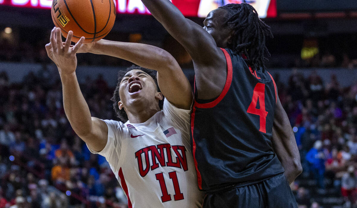 UNLV Rebels guard Dedan Thomas Jr. (11) takes a body shot from San Diego State Aztecs forward J ...