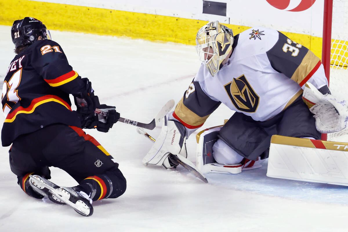 Vegas Golden Knights goalie Adin Hill makes a save against Calgary Flames' Kevin Rooney during ...