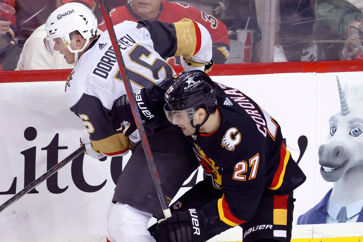 Vegas Golden Knights' Pavel Dorofeyev, left, works against Calgary Flames' Matt Coronato during ...