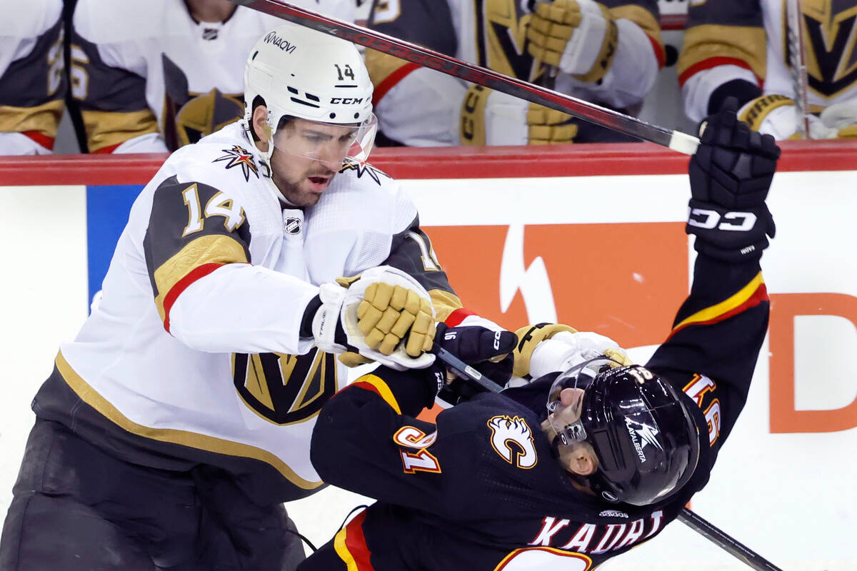 Vegas Golden Knights' Nicolas Hague, left, checks Calgary Flames' Nazem Kadri during the third ...