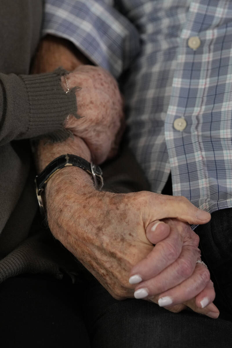 World War II veteran Harold Terens, 100, right, holds hands with Jeanne Swerlin, 96, as they sp ...