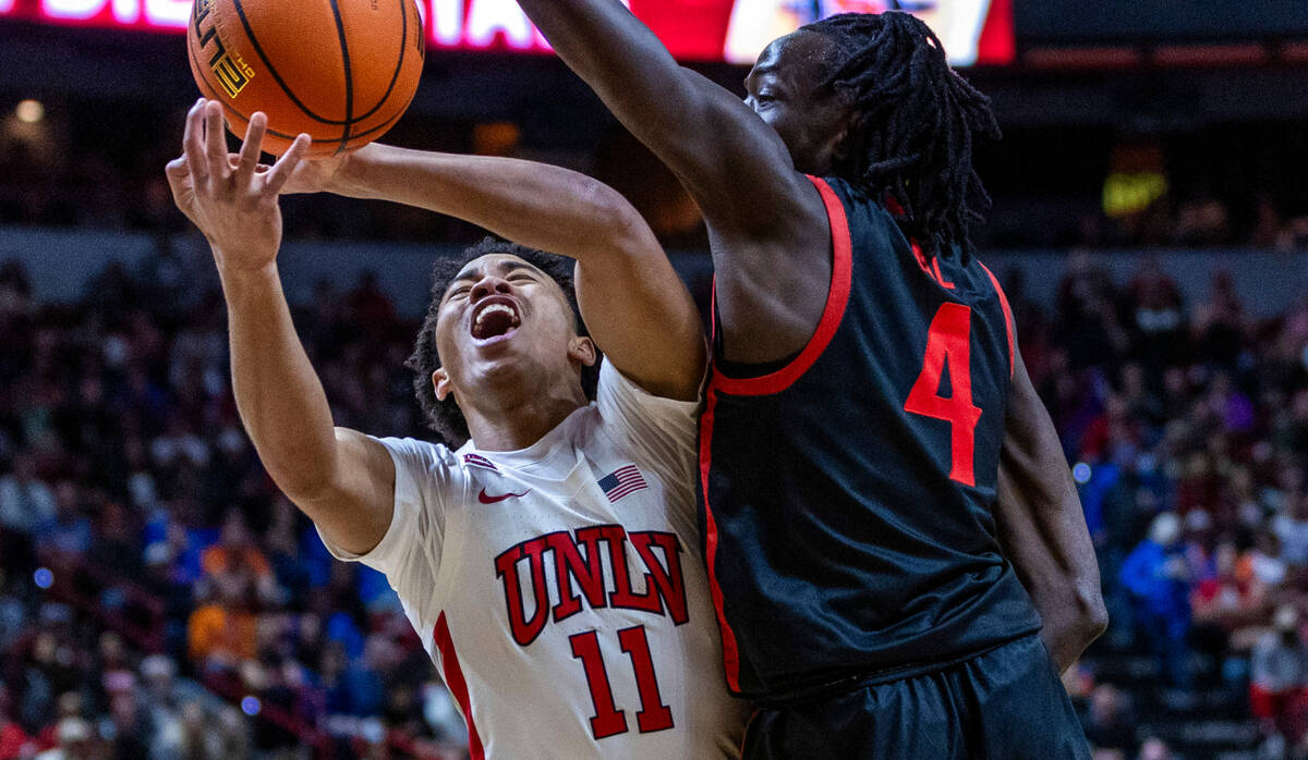 UNLV Rebels guard Dedan Thomas Jr. (11) takes a body shot from San Diego State Aztecs forward J ...