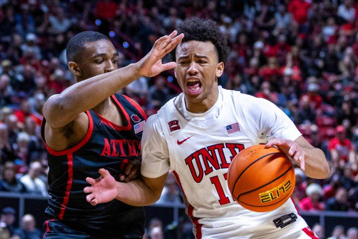 UNLV Rebels guard Dedan Thomas Jr. (11) battles to drive the lane past San Diego State Aztecs g ...