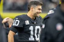 Raiders quarterback Jimmy Garoppolo (10) smiles as he watches the team play from the sideline d ...
