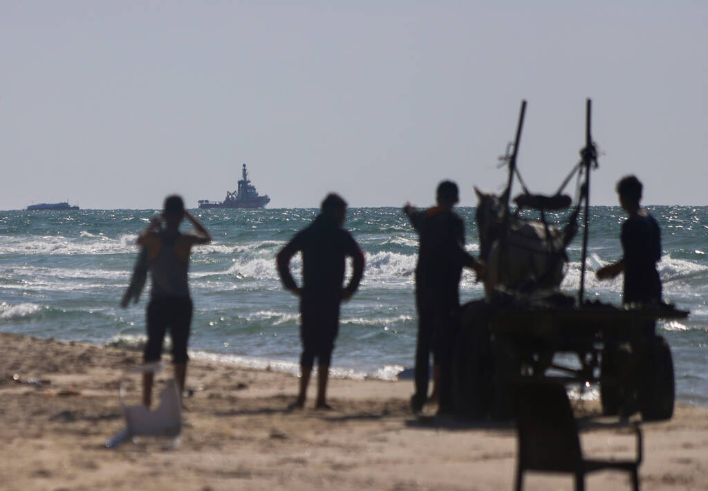 A ship belonging to the Open Arms aid group approaches the shores of Gaza towing a barge with 2 ...
