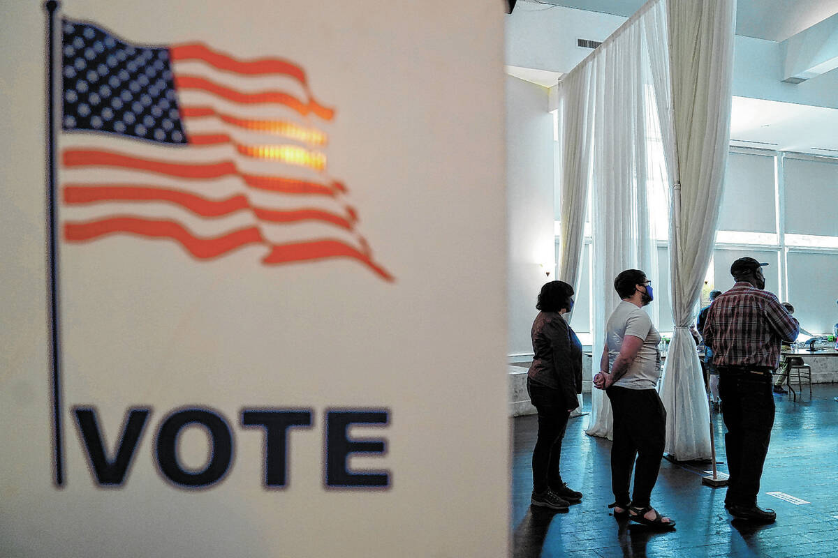 People wait in line to vote in the Georgia's primary election on Tuesday, May 24, 2022, in Atla ...