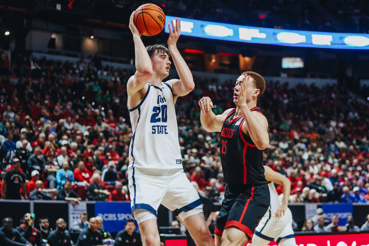 Utah State center Isaac Johnson (20) passes the ball to a teammate as San Diego State forward E ...