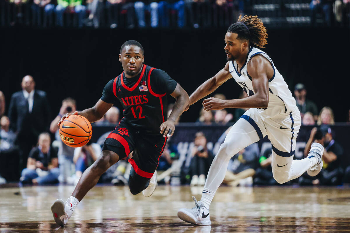 San Diego State guard Darrion Trammell (12) drives the ball down the court as Utah State guard ...