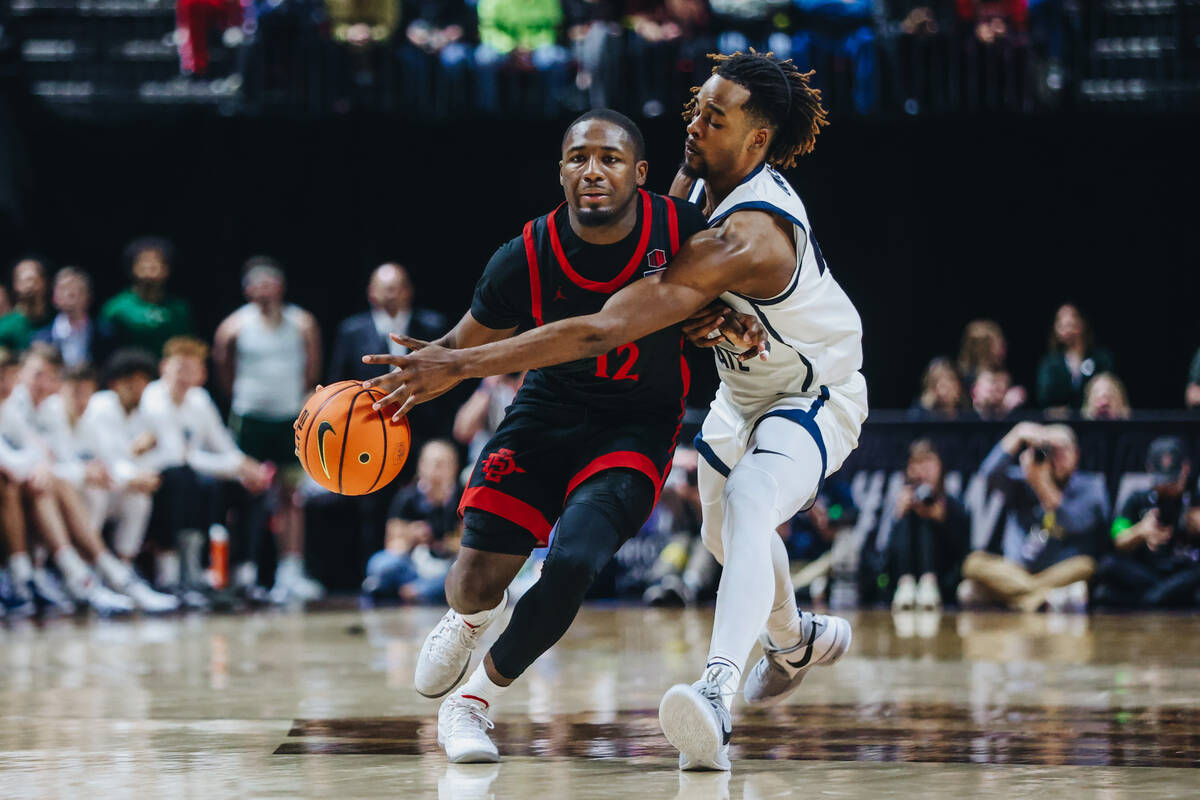 San Diego State guard Darrion Trammell (12) drives the ball down the court as Utah State guard ...