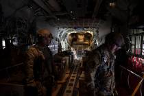 Members of the U.S. Air force stand next to containers with humanitarian aid as they fly toward ...