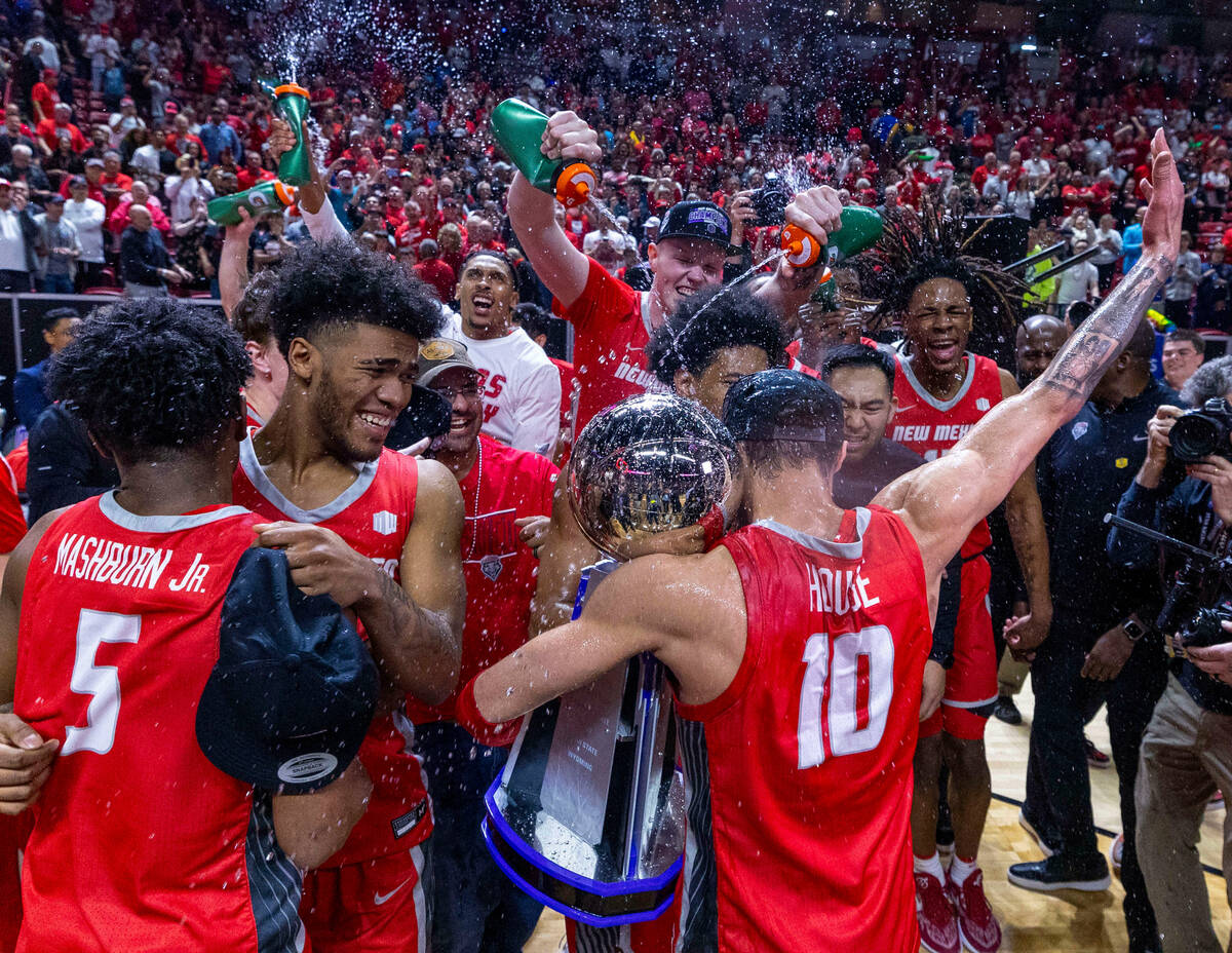 The New Mexico Lobos guard Jaelen House (10) holds the trophy as he celebrates the win over the ...