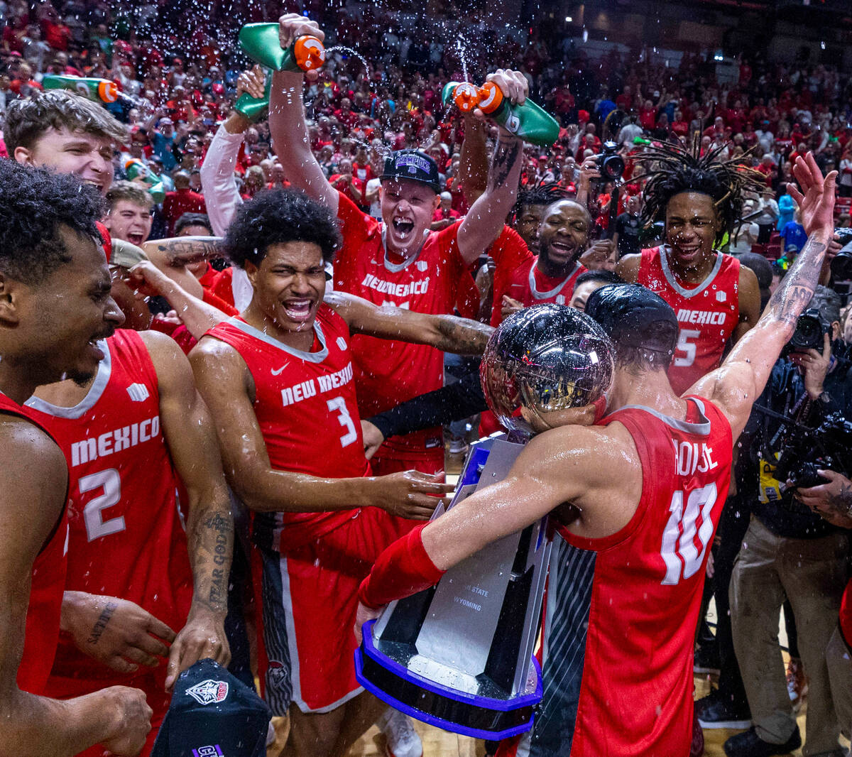 The New Mexico Lobos guard Jaelen House (10) holds the trophy as he celebrates the win over the ...