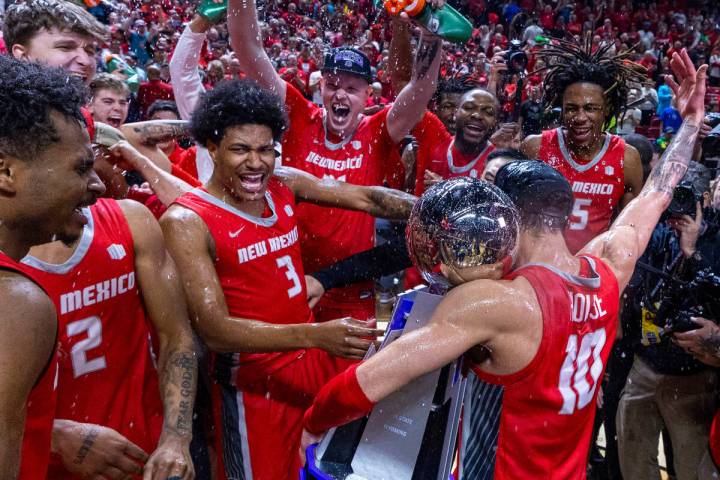 The New Mexico Lobos guard Jaelen House (10) holds the trophy as he celebrates the win over the ...