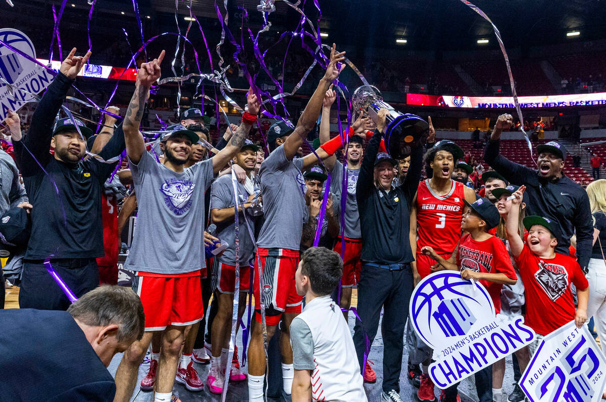 The New Mexico Lobos celebrate their win with the trophy and streamers over the San Diego State ...