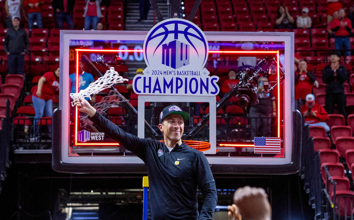 New Mexico Lobos head coach Richard Pitino swings the net after cutting it before teammates and ...