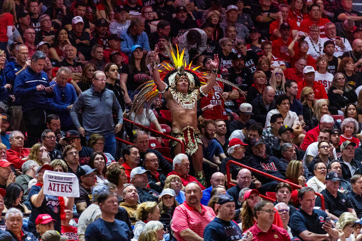 A fan dressed as an Aztec cheers on the San Diego State Aztecs guard BJ Davis (10) against the ...
